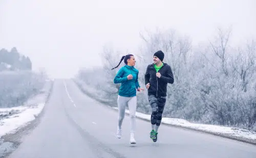 couple jogging in the snow to keep heart healthy even during winter