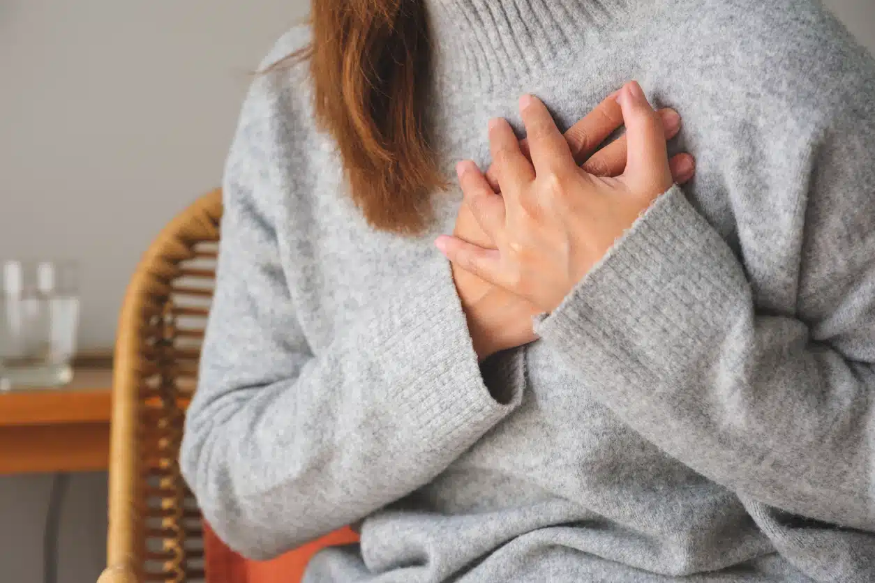 Closeup image of a woman with hands on chest, sudden heart attack, suffering from chest pain Heart Disease In Women